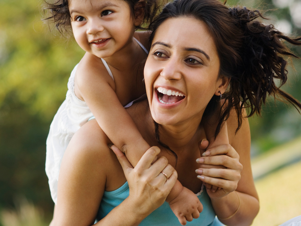 little girl piggybacking her mother