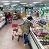 FILE - A woman shops in the frozen foods section at Trader Joe's. The grocery store recently unvailed a new snack called Perfectly Pickled Pups.