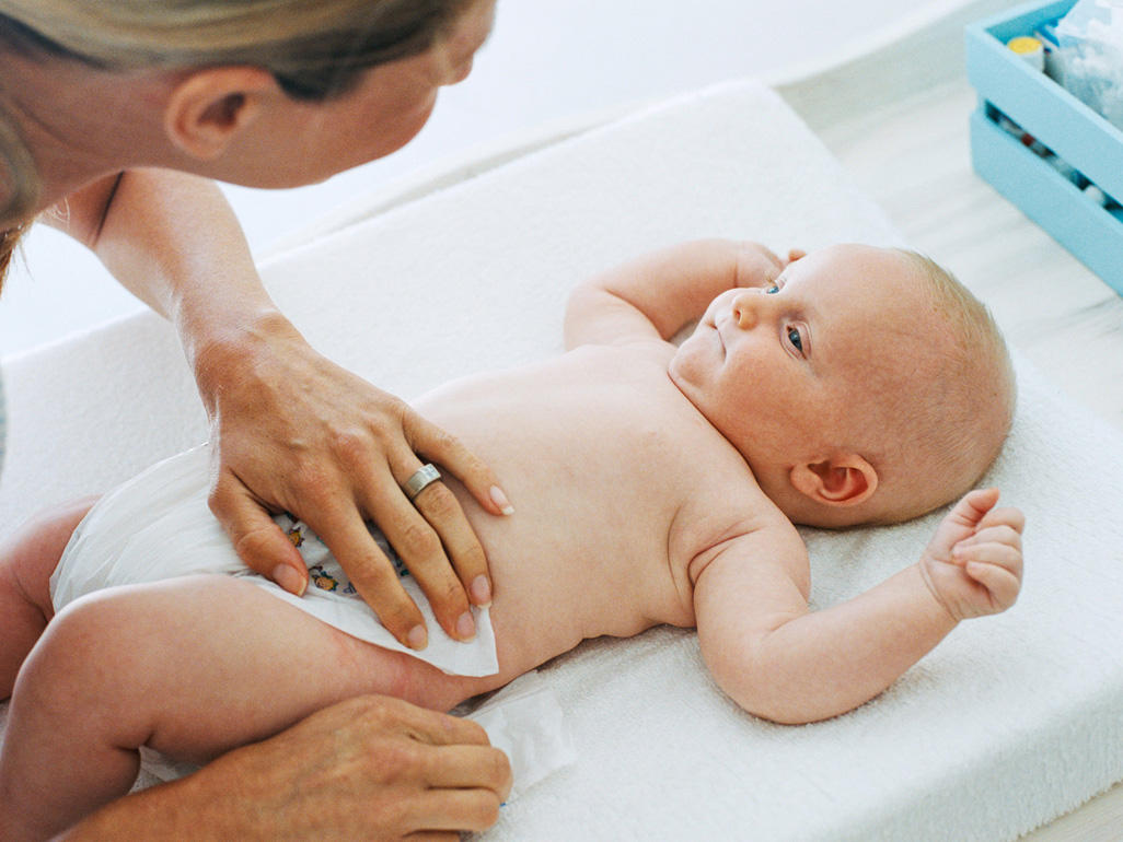 Mum talking to baby while changing nappy