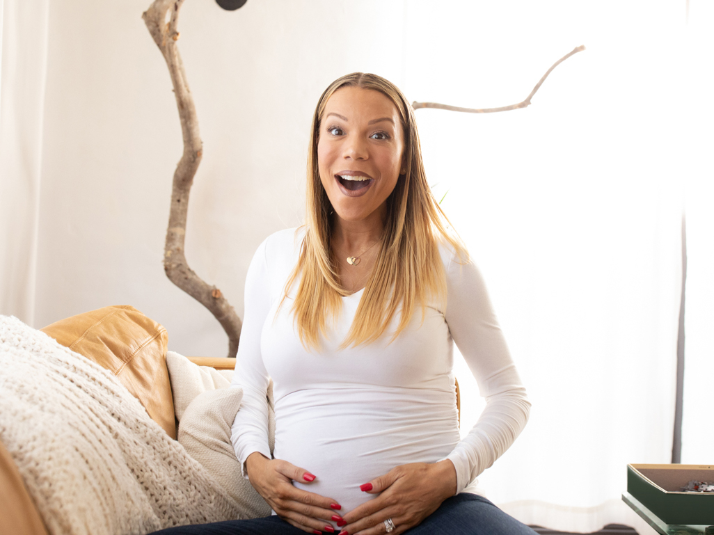 Woman on sofa feeling baby kick