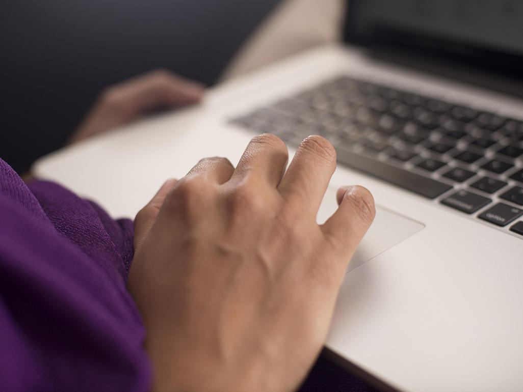 fingers typing on a laptop