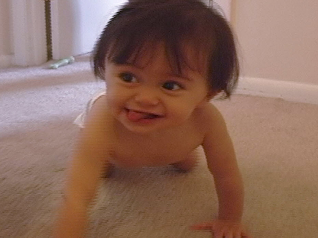 baby with long hair crawling on carpet