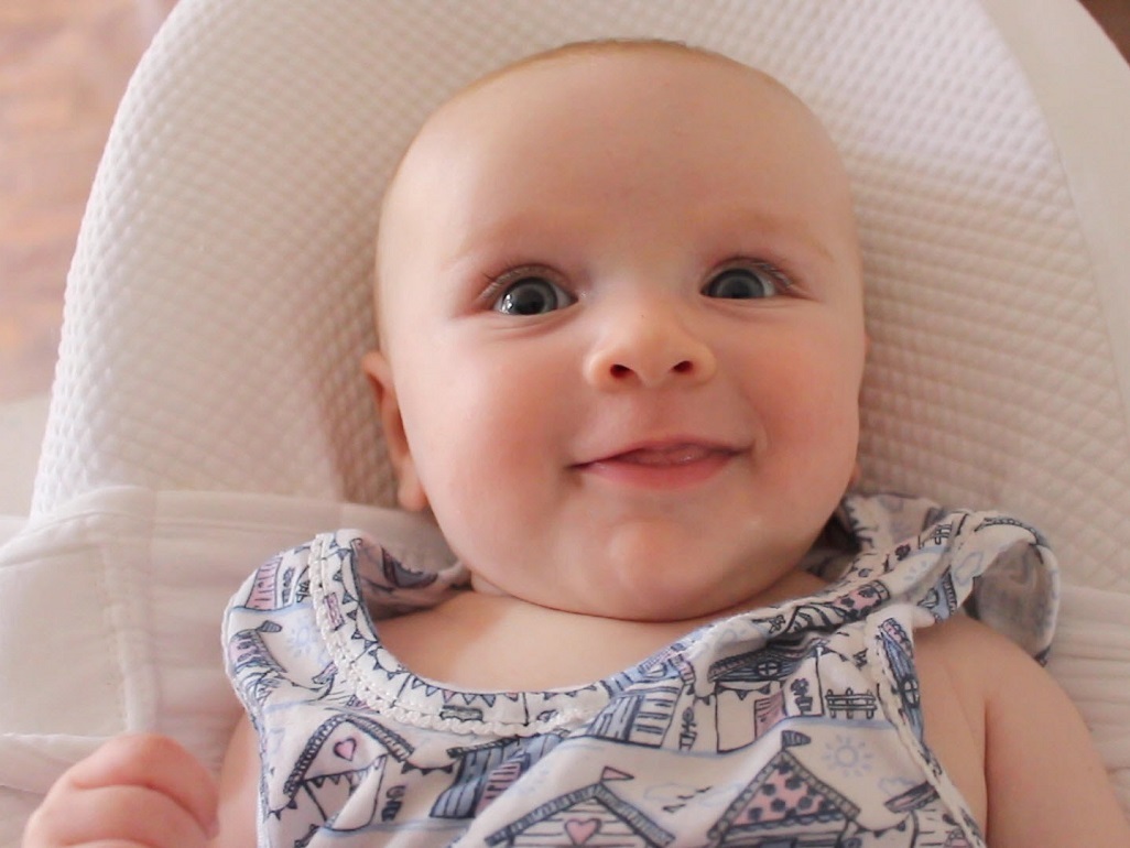 baby in rocker smiling