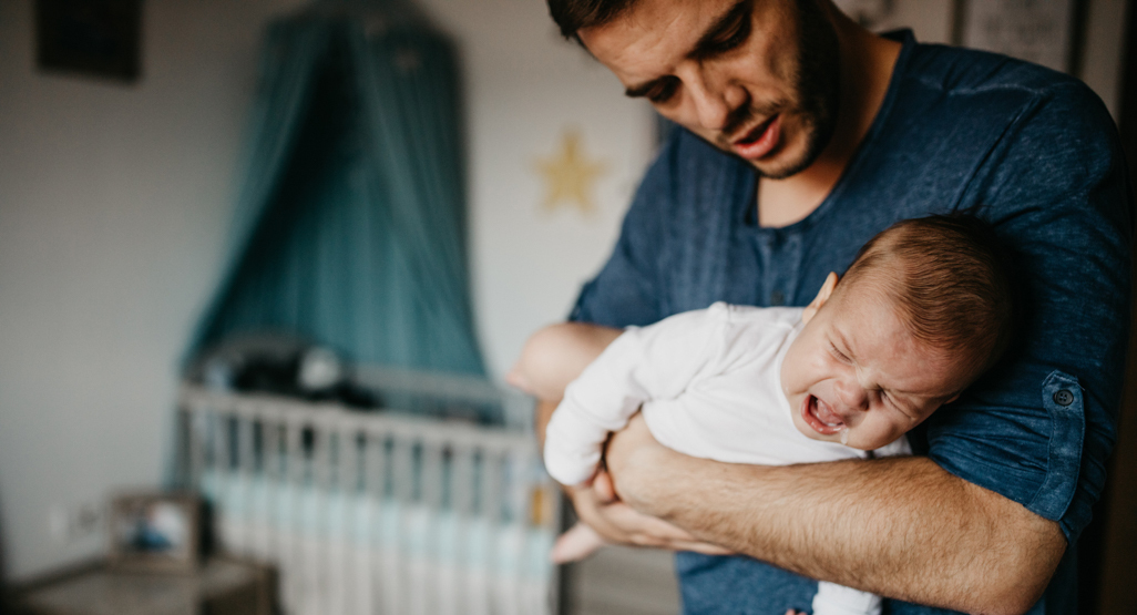 father trying to soothe his crying baby