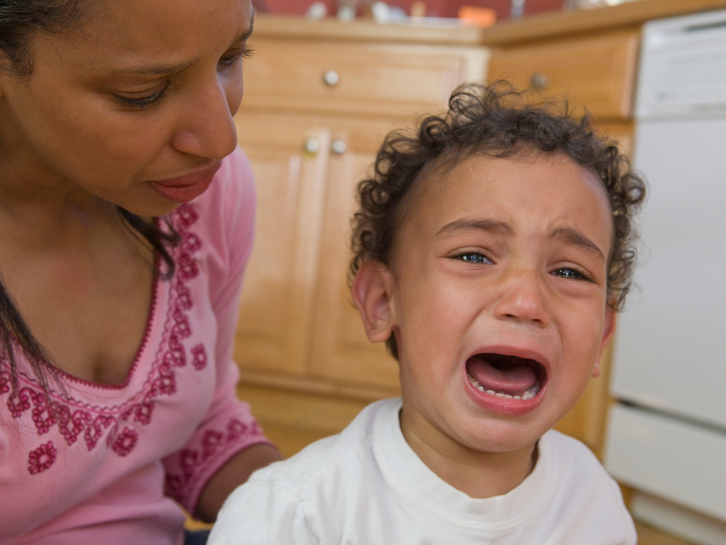 crying baby consoled by mother