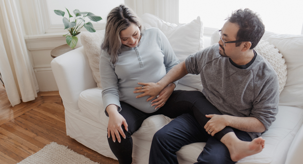 pregnant woman and partner rubbing her belly