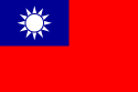 A red flag, with a small blue rectangle in the top left hand corner on which sits a white sun composed of a circle surrounded by 12 rays.