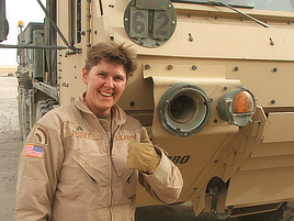 Cristina Frisby poses for a photographic portrait wearing a U.S. Army uniform while giving a thumbs-up gesture.