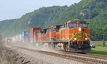 Orange locomotive hauling freight