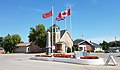 Ensign Aħmar Kanadiż, Bandiera tar-Royal Union, u Bandiera Kanadiża ħdejn cenotaph f'Cartwright, Manitoba