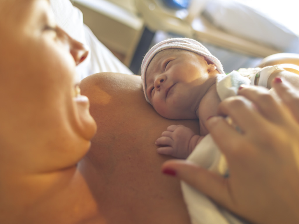 mom holding baby on chest after birth