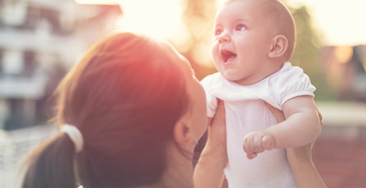 Mother holding up baby