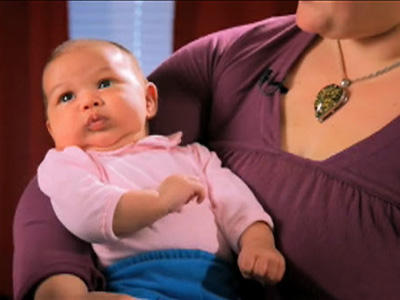 Midwife shows Dad the cradle hold.