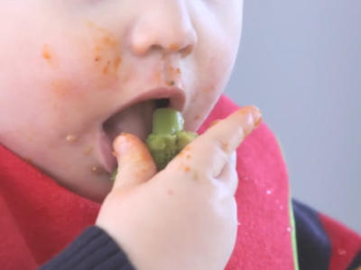 Toddler eating broccoli