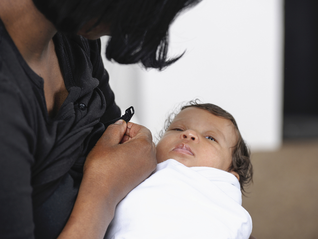 Woman trying to breastfeed uninterested baby