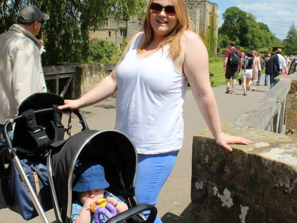 Woman standing next to a baby in a buggy