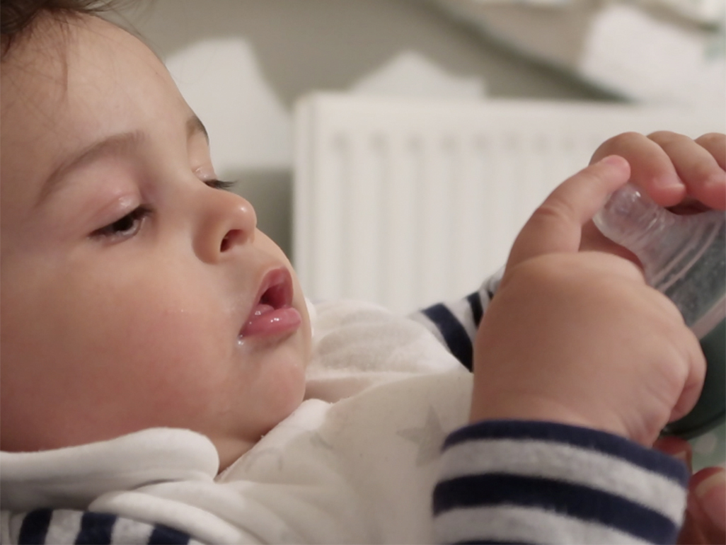 Baby Cian playing with his bottle