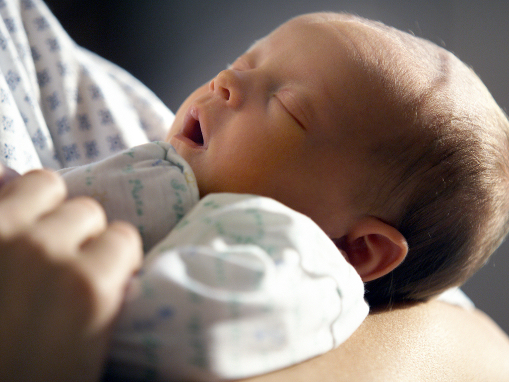 Newborn sleeping in her mum's arms