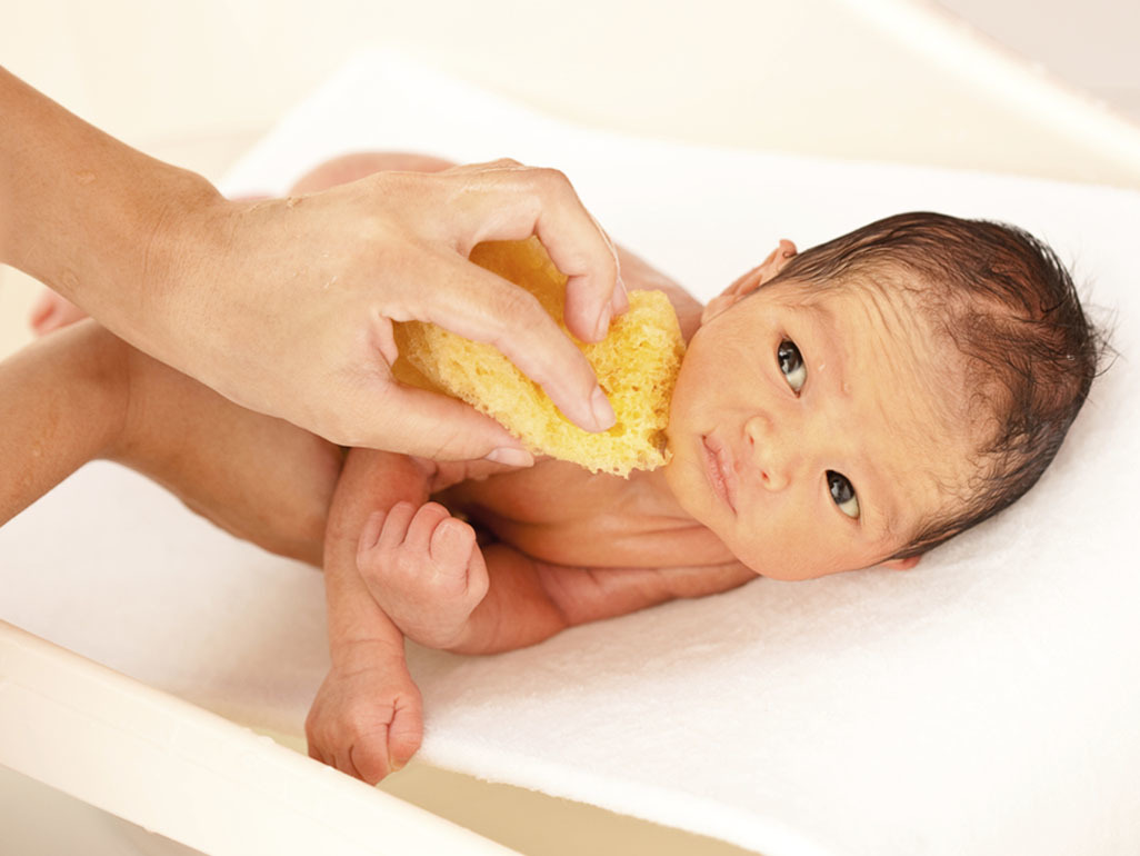 Newborn baby being bathed