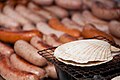 A scallop being grilled next to sausages in Japan