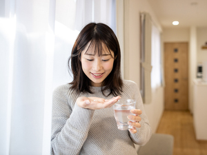 woman looking at prenatal vitamin in her hand