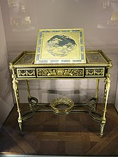 Writing table of Marie-Antoinette; by Adam Weisweiler; 1784; oak, ebony and sycamore veneer, Japanese lacquer, steel, bronze gilt; 73.7 x 81. 2 cm; Louvre[69]