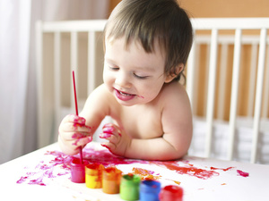 Toddler smiling and painting