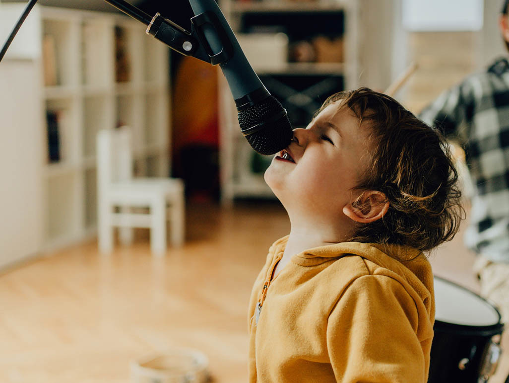 little boy singing into a microphone