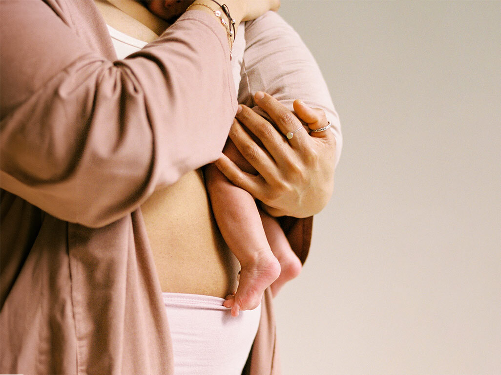 Mother holding newborn baby in a robe