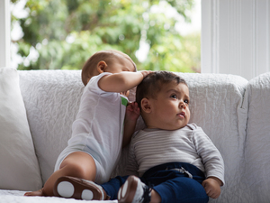 two toddlers on a sofa at home