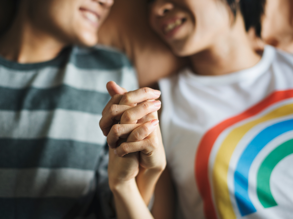 happy couple holding hands in bed