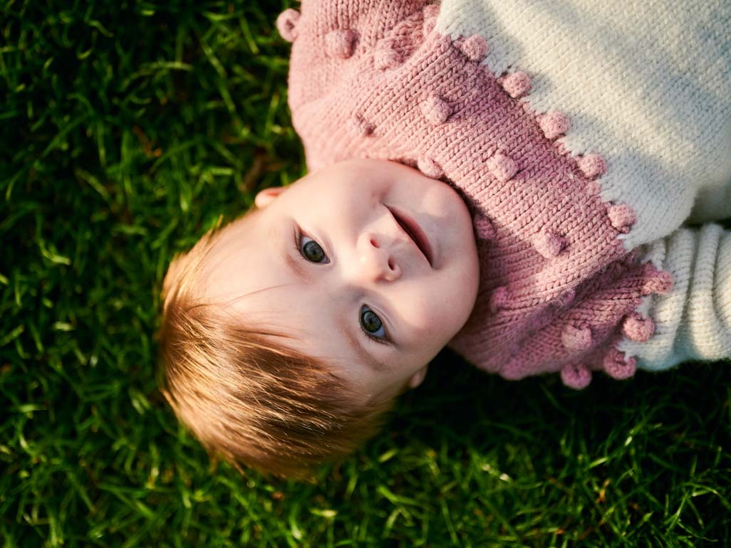 A baby laying in grass