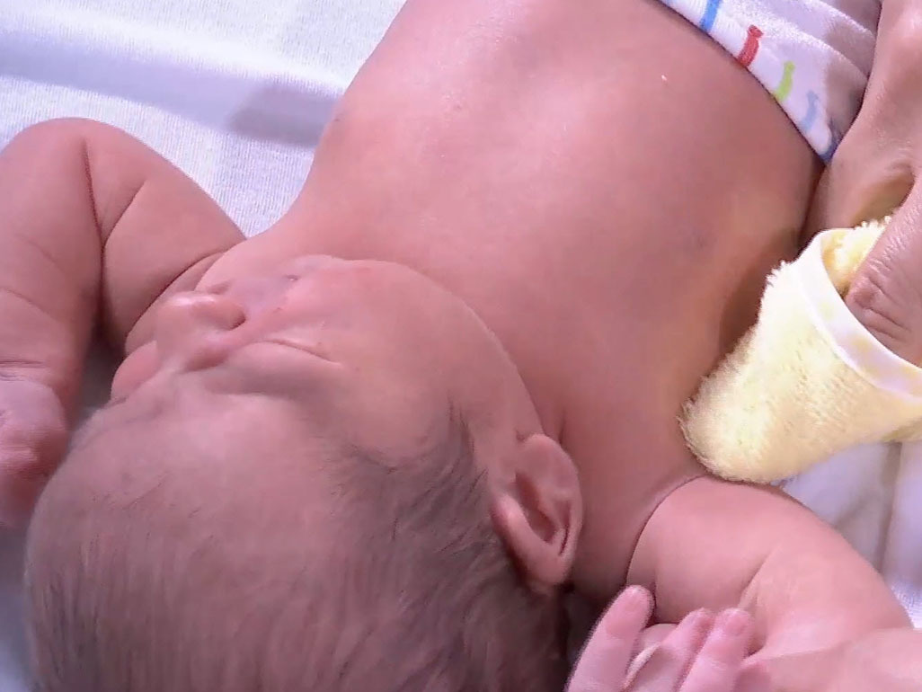 baby having his armpit cleaned with a cloth