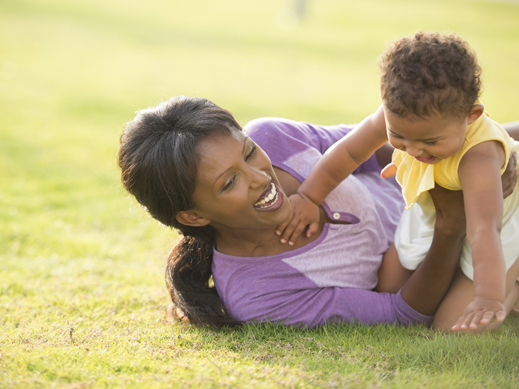 mother and baby playing on the grass in the park