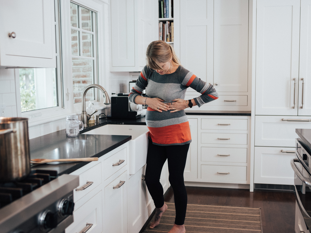 Pregnant woman holding ribs