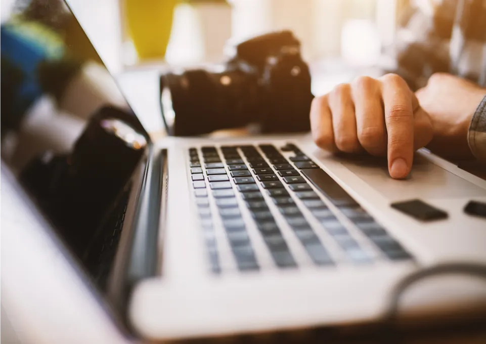 A laptop computer with a camera in the background