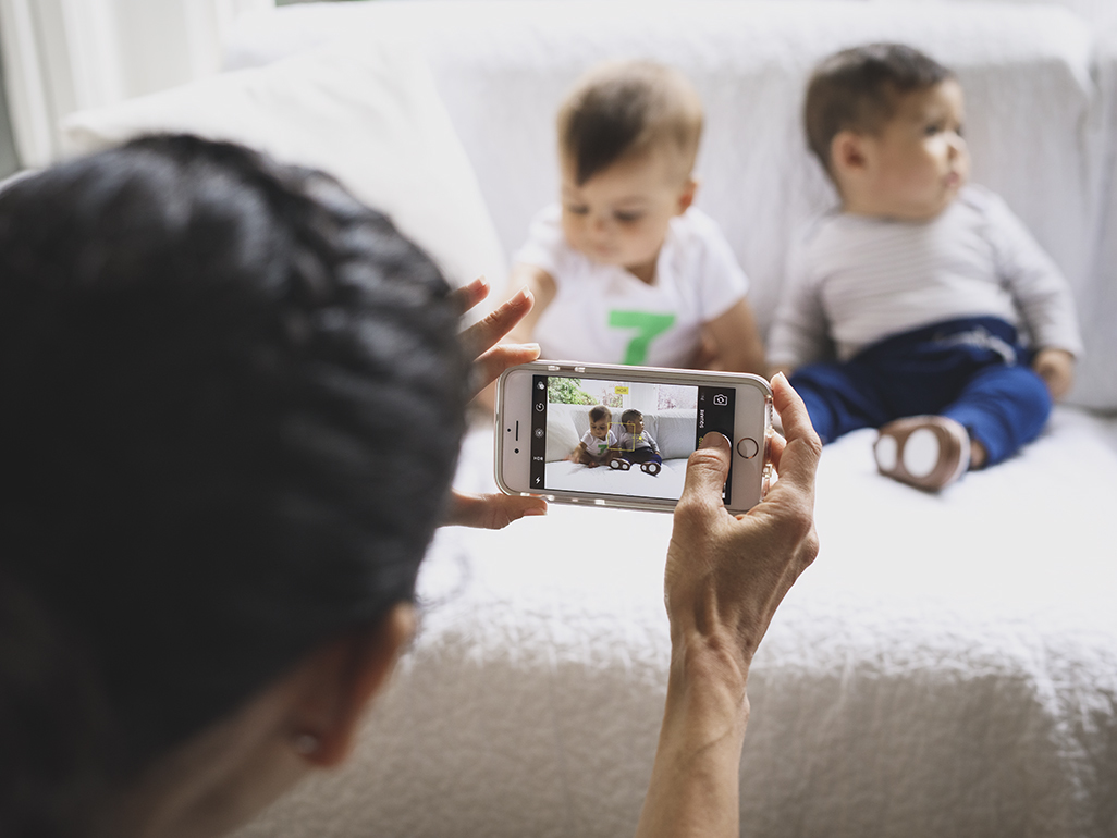 woman taking a picture of two toddlers