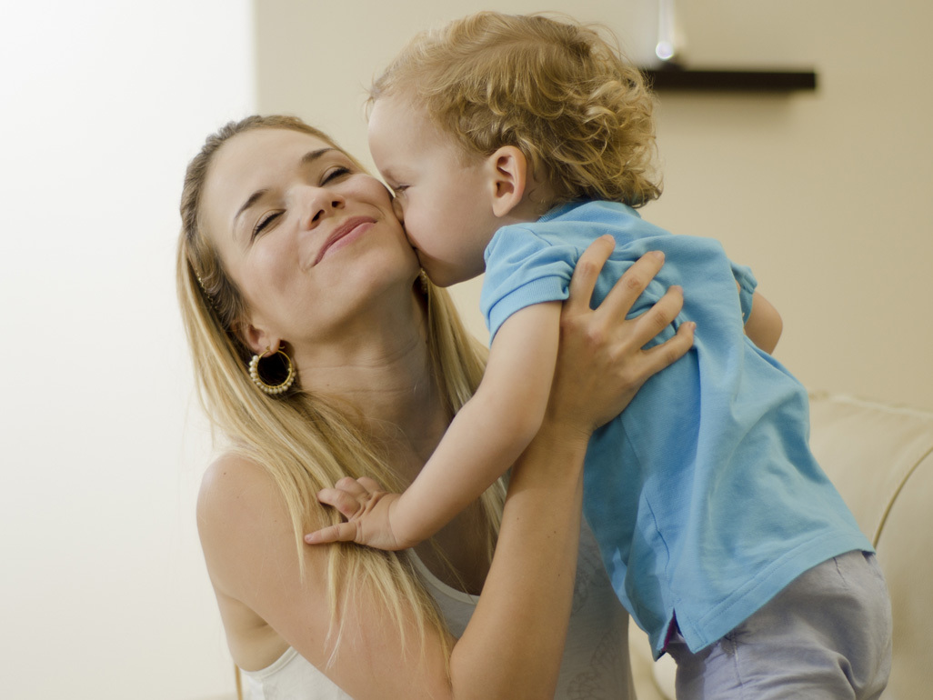 Toddler kissing woman on cheek