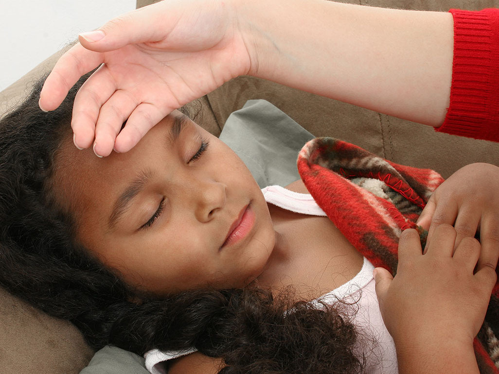 mom putting her hand on little girl's forehead