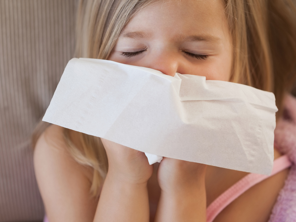 little girl wiping nose with tissue