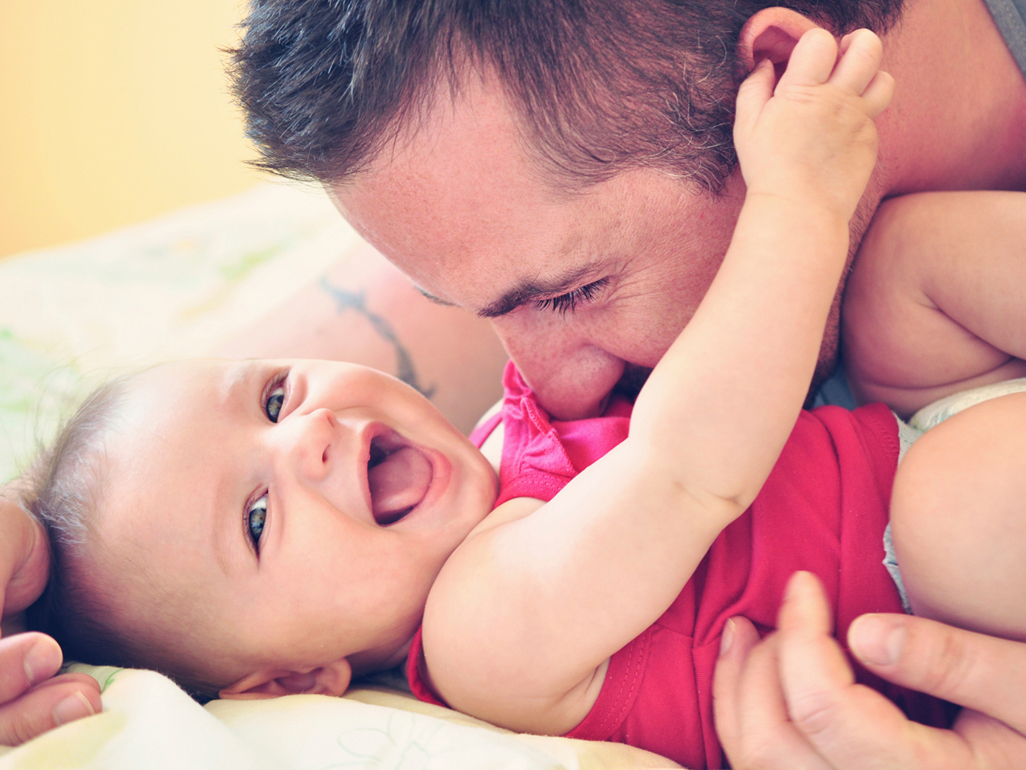 Dad playing with baby making baby laugh