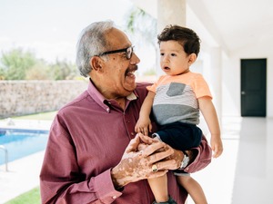 smiling grandfather holding young grandbaby 