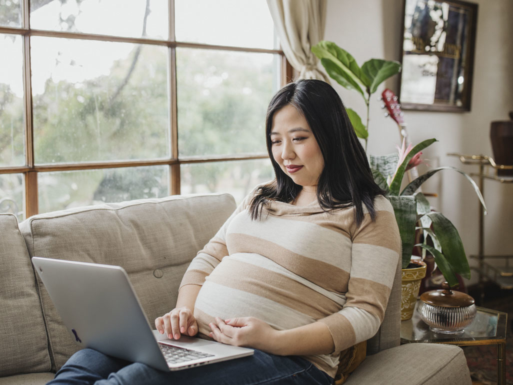 Pregnant woman browsing on laptop