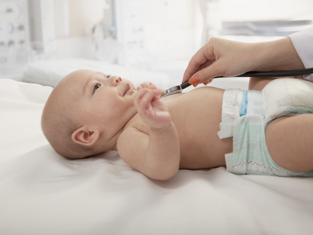 Bebê branco sendo examinado por médico