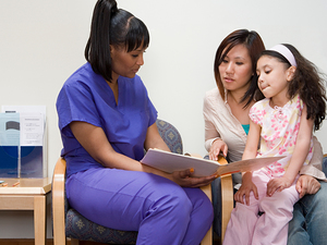 woman doctor showing some documents to mother and daughter