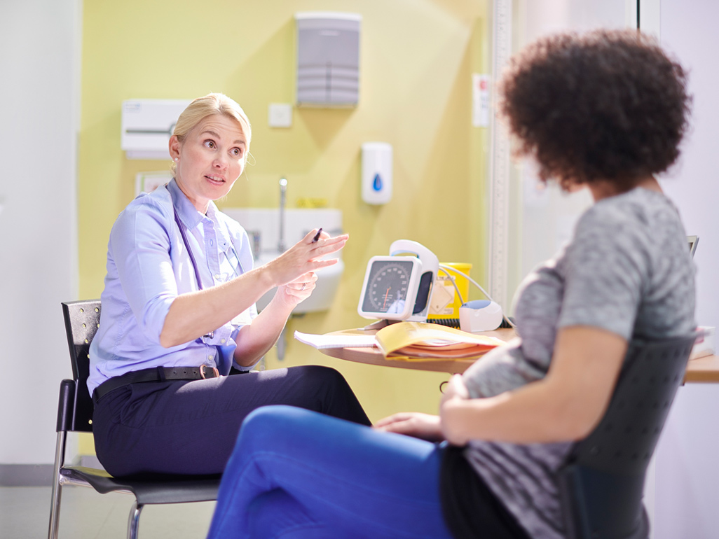 Pregnant woman talking to her doctor