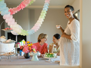 pregnant woman smiling at party with others in the background