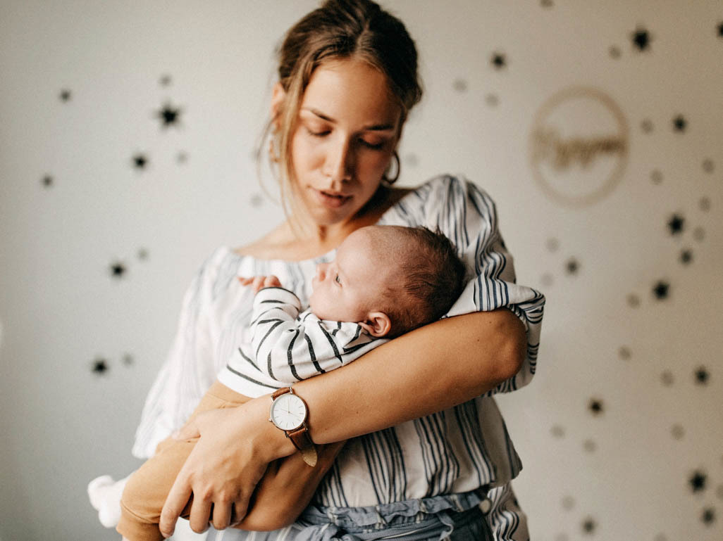 mother rocking baby in nursery