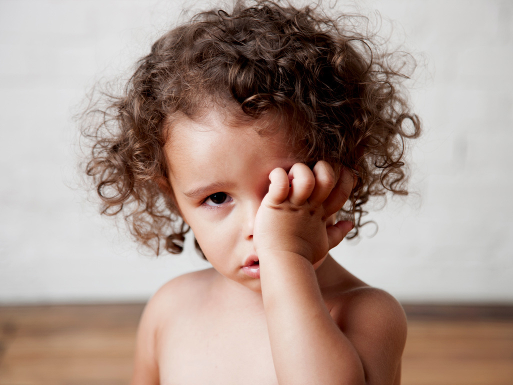 Toddler rubbing her eye.