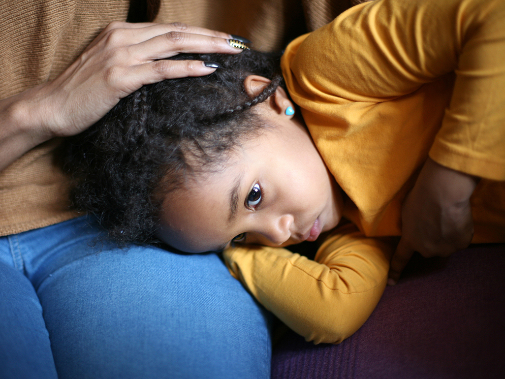 young child laying in parents lap